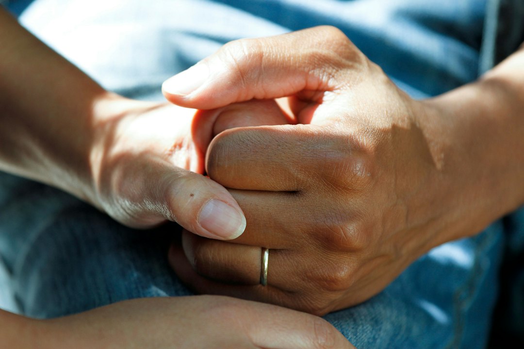 Hands clasped together representing care connected across family and agency